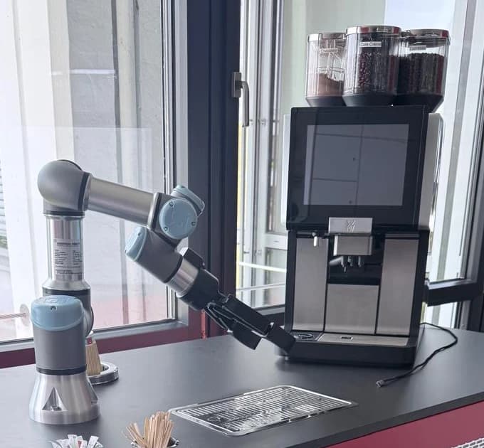 Roboterarm und Kaffeemaschine des Coffee Bot im Detail.
